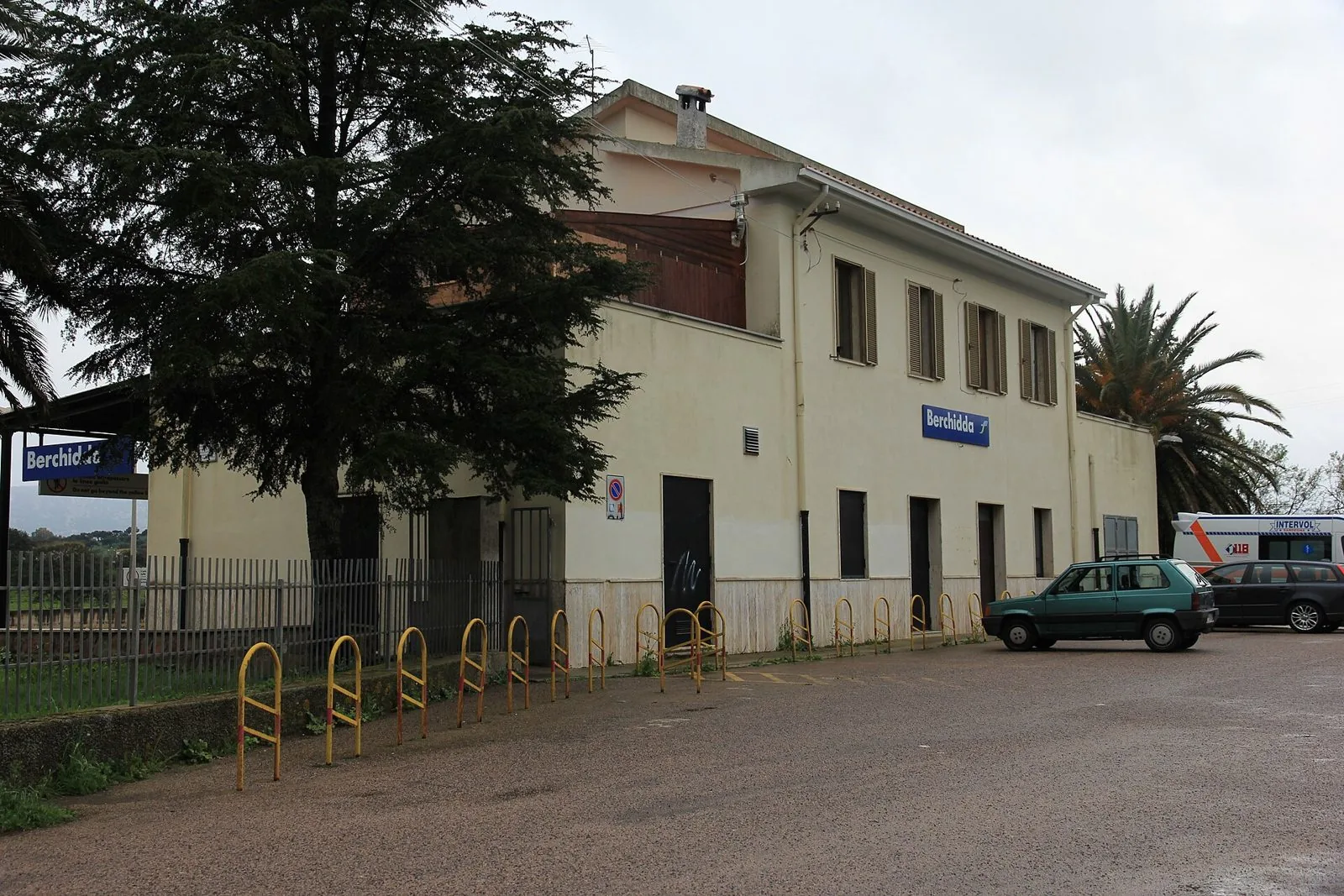 Edificio della stazione ferroviaria di Berchidda con il cartello blu del nome del paese