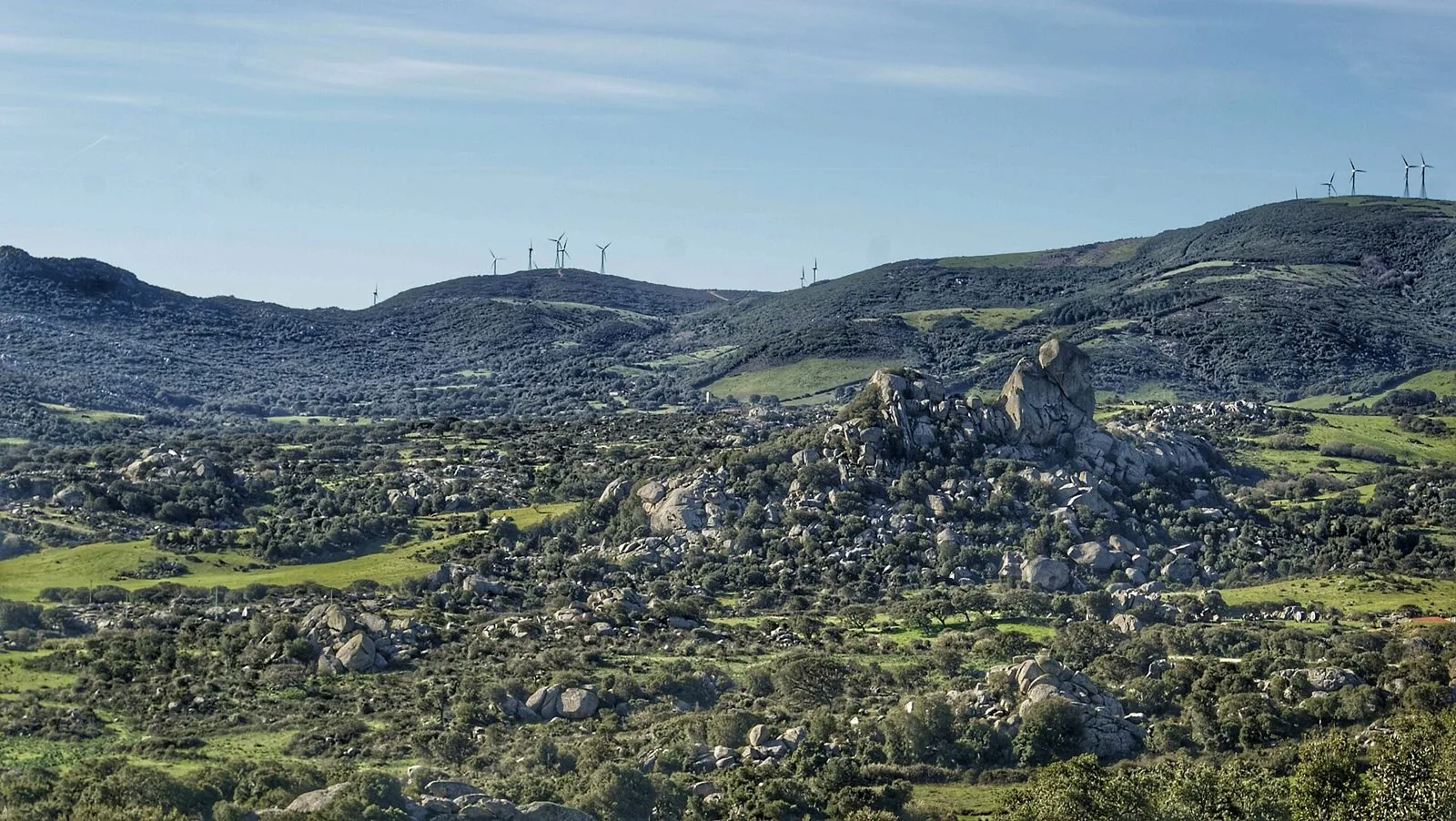 Paesaggio della Valle della Luna di Aggius con grandi massi di granito tra la macchia mediterranea e colline sullo sfondo