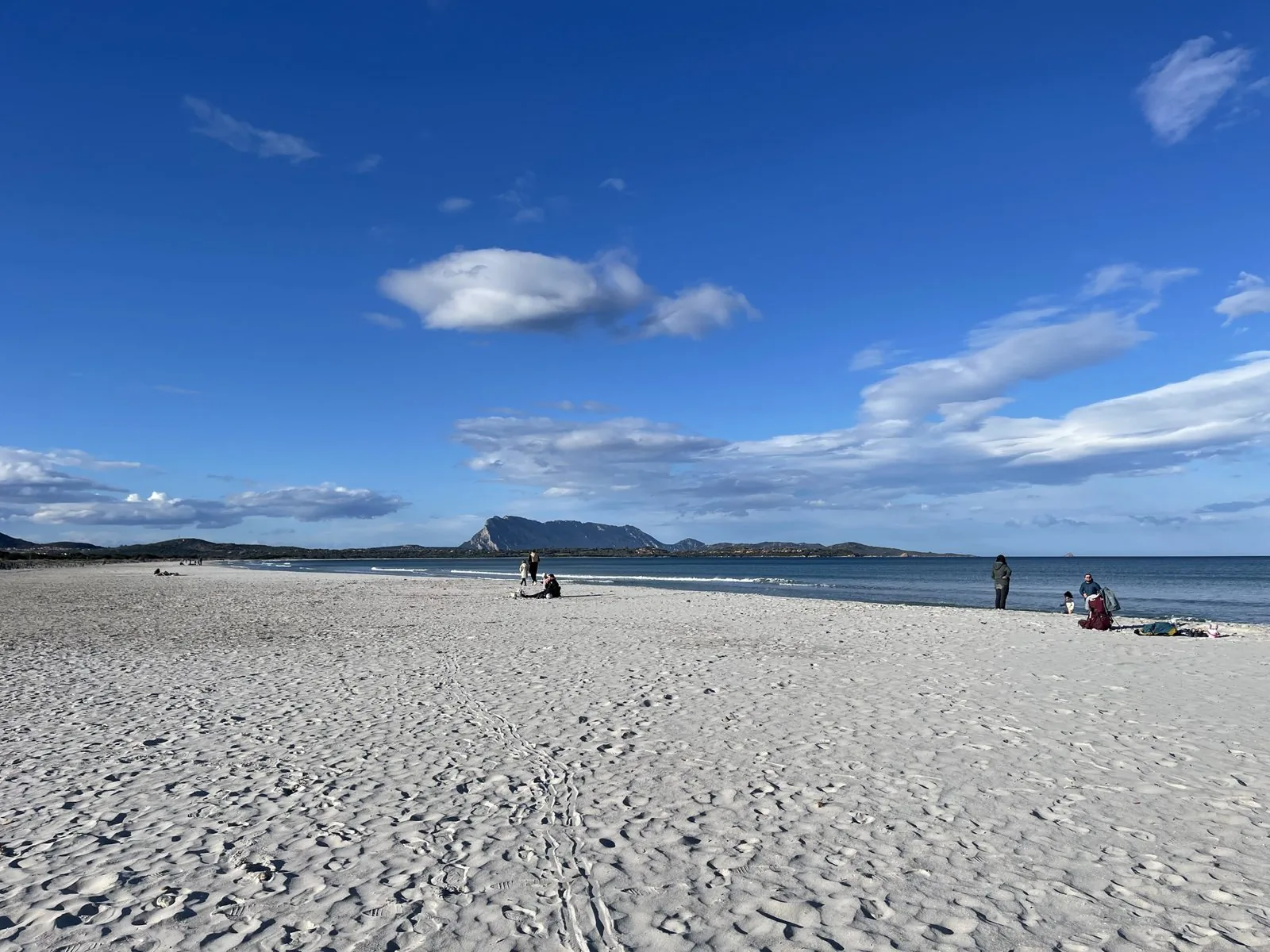 La lunga spiaggia bianca de La Cinta a San Teodoro con l'isola di Tavolara all'orizzonte sotto un cielo azzurro